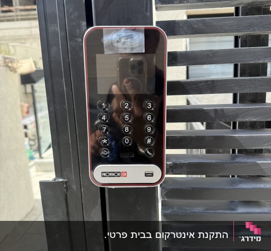 מערכת אינטרקום מותקנת על שער מתכת שחור